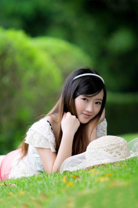 ‘Photoshop将趴在草地上的可爱女孩加上甜美的秋季黄褐色‘