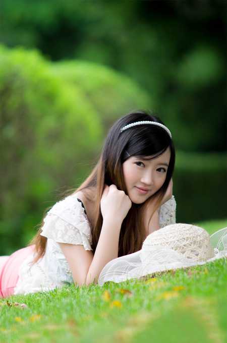 ‘Photoshop将趴在草地上的美女图片增加小清新的粉红色‘